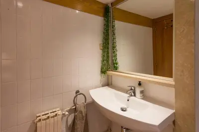 a bathroom with a sink and a mirror at INNOUTHOME Apartamento Eixample Barcelona in Barcelona