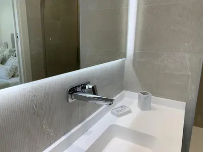 a bathroom sink with a faucet and a mirror at Sitges Spaces Oasis Suites- 4 Bedroom, 4 Ensuite Bathrooms, Terrace, Pool, Sitges Centre in Sitges