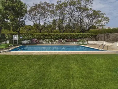 a swimming pool in a yard with green grass at Sitges Spaces Oasis Suites- 4 Bedroom, 4 Ensuite Bathrooms, Terrace, Pool, Sitges Centre in Sitges