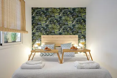 a bedroom with a bed with a table and glasses of wine at Beach, Restaurants and Views in Castelldefels