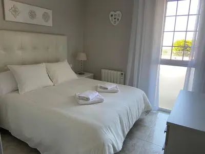 a bedroom with a white bed with towels on it at Karin Palma Fiesta-Vallpineda-Sitges in Sant Pere de Ribes