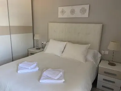 a white bed with two towels on top of it at Karin Palma Fiesta-Vallpineda-Sitges in Sant Pere de Ribes