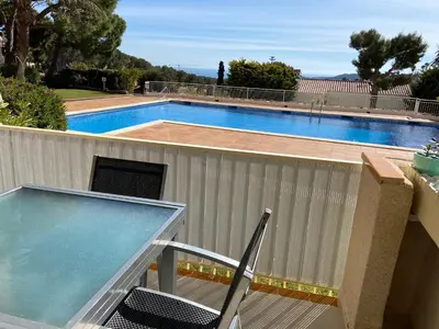a table and a chair next to a swimming pool at Karin Palma Fiesta-Vallpineda-Sitges in Sant Pere de Ribes