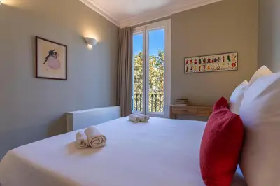 a bedroom with a bed with red pillows and a window at Bcn Paseo De Gracia Rocamora Apartment in Barcelona