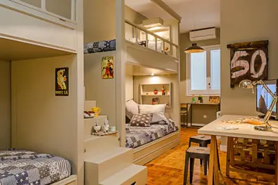a small room with two bunk beds and a table at Bcn Paseo De Gracia Rocamora Apartment in Barcelona