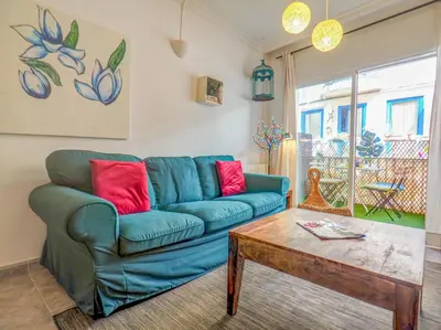 a living room with a blue couch and a coffee table at The Beach Holi Apartment by Hello Homes Sitges in Sitges