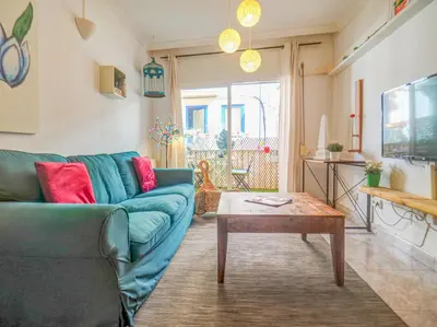 a living room with a blue couch and a coffee table at The Beach Holi Apartment by Hello Homes Sitges in Sitges