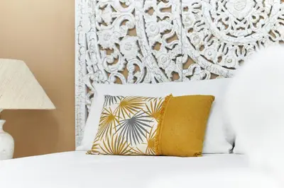 a bed with a yellow pillow and a white headboard at HA Diputació terrace apartment in Barcelona