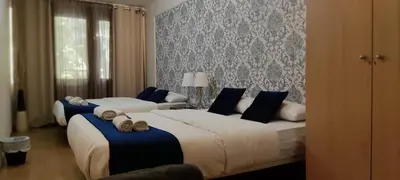 two beds in a bedroom with blue and white at Guest House Barcelona Bruc in Barcelona