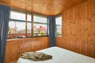 a bedroom with wooden walls and a bed and a window at Casa Cosi - Industria in Barcelona