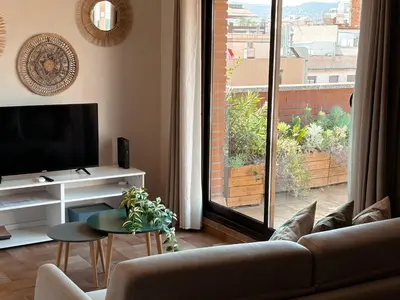 a living room with a couch and a large window at Casa Cosi - Industria in Barcelona