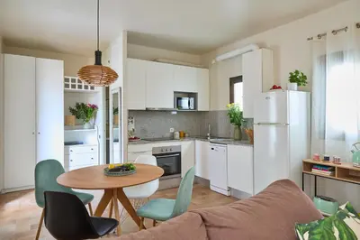 a kitchen and living room with a table and chairs at Casa Cosi - Industria in Barcelona