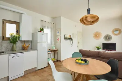 a kitchen and a living room with a table and chairs at Casa Cosi - Industria in Barcelona