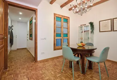 a dining room with a wooden table and blue chairs at Casa Cosi - El Farro 3 in Barcelona