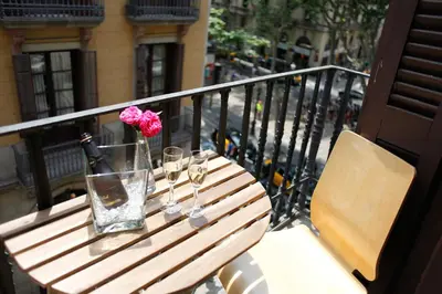 a wooden table with glasses and a bottle of wine at Colom Apartments in Barcelona