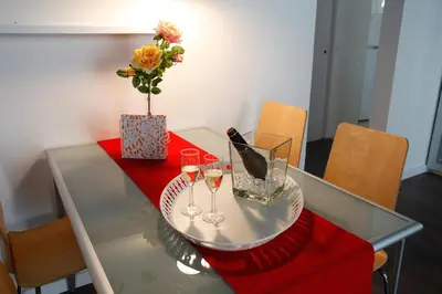 a glass table with wine glasses and a vase with flowers at Colom Apartments in Barcelona