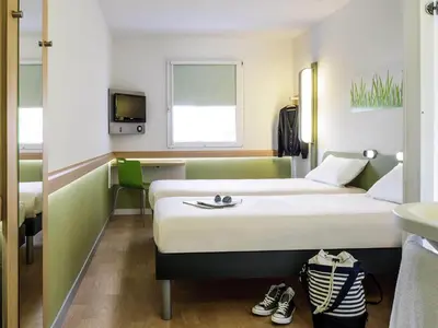 a hotel room with two beds and a window at Ibis Budget Barcelona Sant Andreu De La Barca in Sant Andreu de la Barca