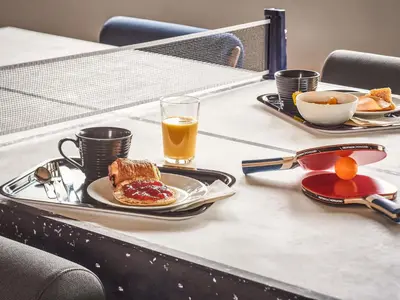 a bakery with two tables and a counter with food at Ibis Budget Barcelona Sant Andreu De La Barca in Sant Andreu de la Barca