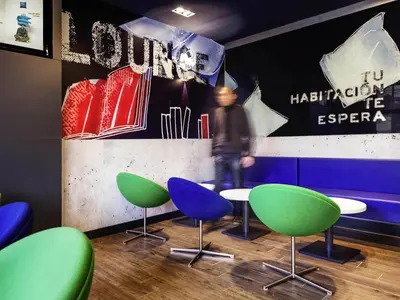 a dining room with colorful chairs and tables at Ibis Budget Barcelona Sant Andreu De La Barca in Sant Andreu de la Barca