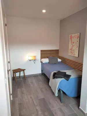 a bedroom with a bed and a table in it at Apartamentos Turísticos Tenor by Bossh! Hotels in Barcelona