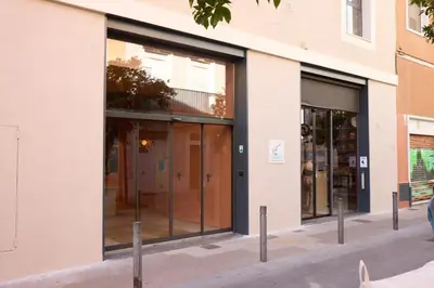 a building with glass doors on a street at Latroupe Poblenou Beach in Barcelona