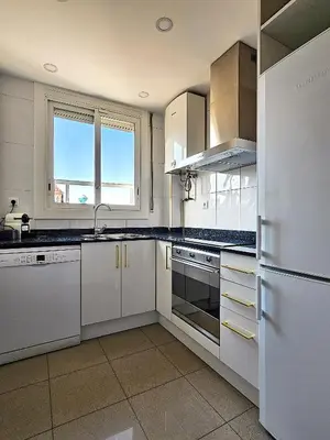 a kitchen with white cabinets and a refrigerator at Classbedroom Fira Business Apartment in Barcelona
