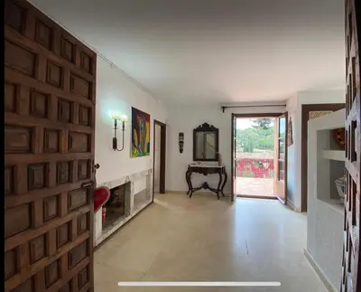 a hallway with a fireplace and a wooden door at Medieval tower & villa by the sea in Caldes d'Estrac
