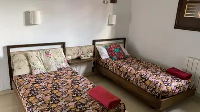 two beds sitting next to each other in a room at Medieval tower & villa by the sea in Caldes d'Estrac
