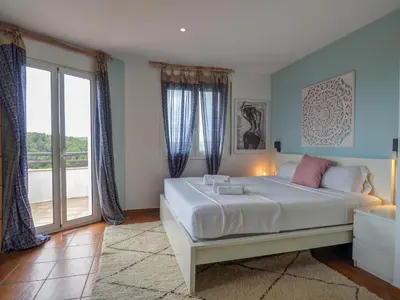 a bedroom with a bed and a large window at Villa Elysian by Hello Homes Sitges in Sant Pere de Ribes
