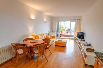 a living room with a table and a couch at Tropical Terrace Apartment by Hello Homes Sitges in Sitges