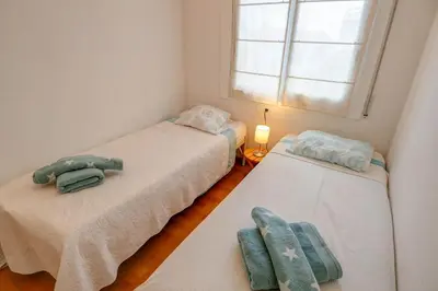 two twin beds in a room with a window at Tropical Terrace Apartment by Hello Homes Sitges in Sitges