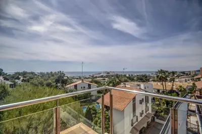 a balcony with a view of a city at Tropical Terrace Apartment by Hello Homes Sitges in Sitges