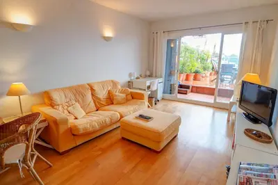 a living room with a couch and a tv at Tropical Terrace Apartment by Hello Homes Sitges in Sitges