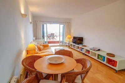 a living room with a table and a couch at Tropical Terrace Apartment by Hello Homes Sitges in Sitges
