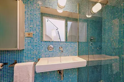 a blue tiled bathroom with a sink and a mirror at Casa de Pueblo junto Barcelona Centro in Vilassar de Dalt