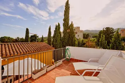 a balcony with a couch and chairs on a roof at Casa de Pueblo junto Barcelona Centro in Vilassar de Dalt