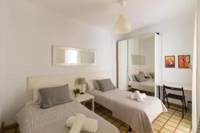 a bedroom with two beds and a mirror at rentBCN City Center Apartment in Barcelona