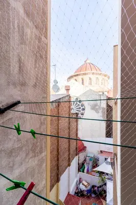 a view of a building through a chain link fence at rentBCN City Center Apartment in Barcelona