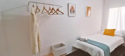 a white bedroom with a bed and a window at Apartamento Centric para 6 cerca de a playa y el tren in Premiá de Mar