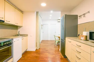 a kitchen with a refrigerator and a table at Alcam Torrent in Barcelona