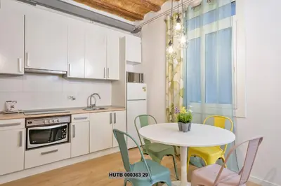 a kitchen with a table and chairs and a sink at Alcam Gignas in Barcelona