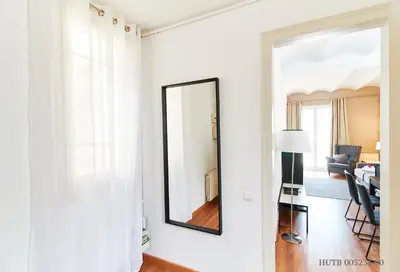 a mirror on a white wall in a living room at Alcam Rizal in Barcelona
