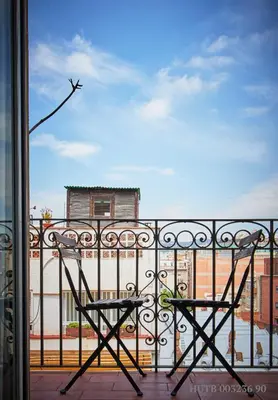 a chair on a balcony with a view of a city at Alcam Rizal in Barcelona