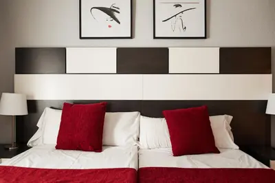 a bedroom with a bed with red and white pillows at Alcam Valencia II in Barcelona