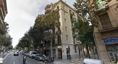 a building on a city street with cars parked on the street at Alcam Valencia II in Barcelona