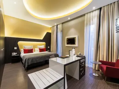 a bedroom with a bed and a desk and a chair at Vincci Gala in Barcelona