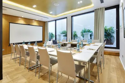 a conference room with tables and chairs and a whiteboard at Vincci Gala in Barcelona