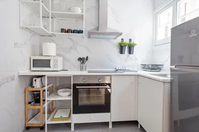a white kitchen with a stove and a microwave at Blau Atic Apartment in Barcelona
