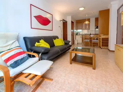 a living room with a black leather couch and a table at Apartment Primer de Maig by Interhome in Sitges