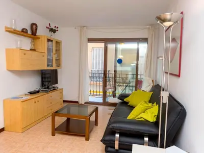 a living room with a black couch and a table at Apartment Primer de Maig by Interhome in Sitges